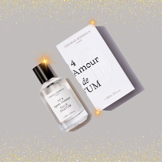 Botella de apres l amour de Thomas Kosmala Paris, con un diseño minimalista en blanco y un tapón negro, presentada junto a su caja con un toque de brillo dorado.