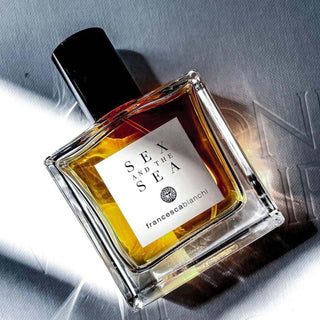 Botella sofisticada de Sex and the Sea Francesca Bianchi, con un diseño en tonos ámbar y un tapón negro, capturada bajo una luz brillante.