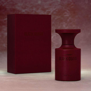 Botella elegante de Black Guava de BORNTOSTANDOUT, con un diseño audaz en tonos burdeos y un acabado extrait de parfum, presentada junto a su caja a juego.